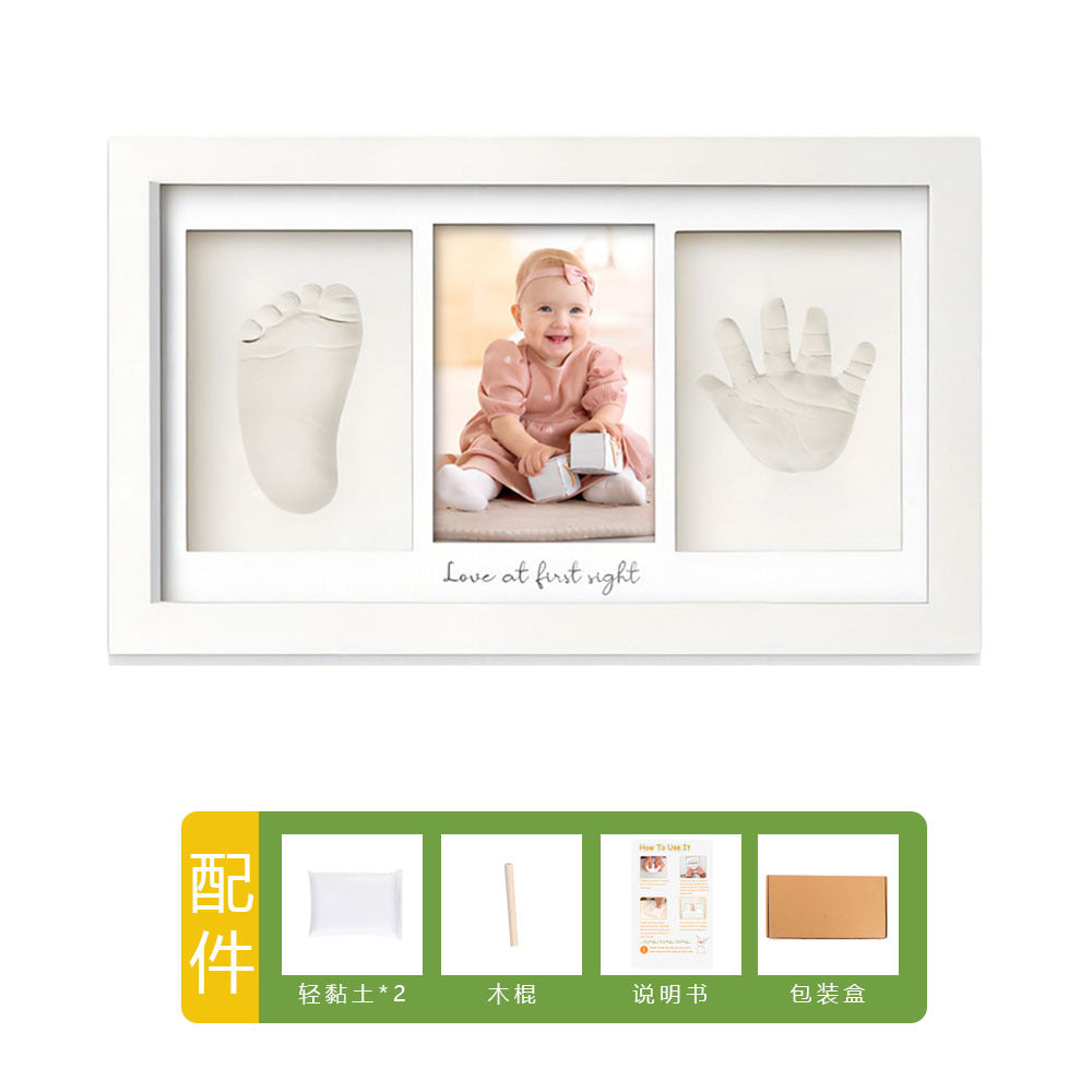 DIY hollow photo frame with baby's 100-day and first birthday hand and footprints, pet paw prints, and baby hand and footprint clay keepsakes.