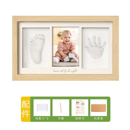 DIY hollow photo frame with baby's 100-day and first birthday hand and footprints, pet paw prints, and baby hand and footprint clay keepsakes.