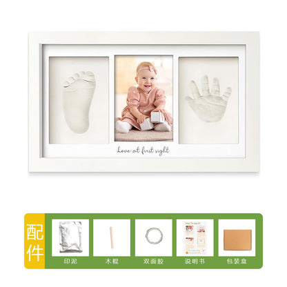 DIY hollow photo frame with baby's 100-day and first birthday hand and footprints, pet paw prints, and baby hand and footprint clay keepsakes.