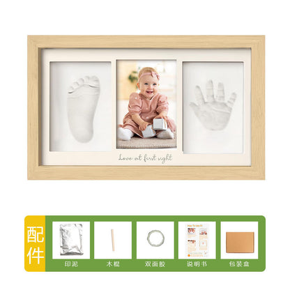 DIY hollow photo frame with baby's 100-day and first birthday hand and footprints, pet paw prints, and baby hand and footprint clay keepsakes.