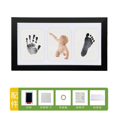 DIY hollow photo frame with baby's 100-day and first birthday hand and footprints, pet paw prints, and baby hand and footprint clay keepsakes.