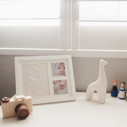 DIY hollow photo frame with baby's 100-day and first birthday hand and footprints, pet paw prints, and baby hand and footprint clay keepsakes.